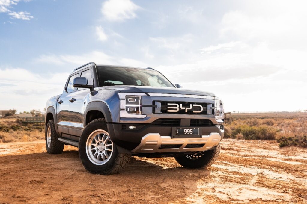 A blue BYD Shark ute parked on a dirt track fitted with Predator New Mutant X-AT all-terrain tyres.